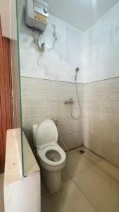 a bathroom with a toilet and a shower at Sanga Hotel in Gabung