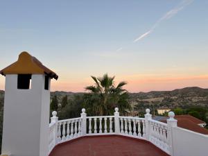 a white house with a balcony with a sunset at Villa Canario in Arboleas