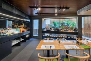 a restaurant with wooden tables and chairs and a counter at Occidental Diagonal 414 in Barcelona