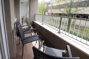 a balcony with three chairs and a balcony at Apartman Dijamant in Sarajevo