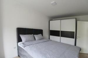 a bedroom with a large bed and a large mirror at Apartman Dijamant in Sarajevo