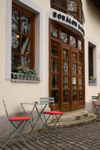 a table and chairs in front of a building at Borálom Stúdió Apartman Tokaj in Tokaj
