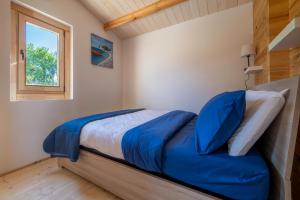 a bedroom with a bed with blue sheets and a window at Atessa Escapes in Atessa