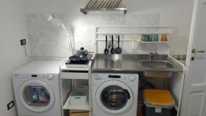 a small kitchen with a washing machine and a sink at B&B Resto al Sud 2 in Salerno