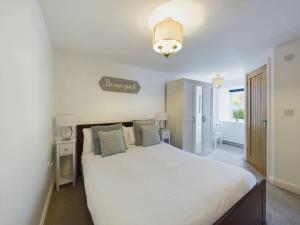 a bedroom with a white bed and a sign on the wall at Charming 3 Bedroom Home in the Heart of Stanhope in Stanhope