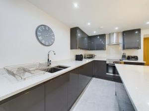 a large kitchen with a large clock on the wall at Charming 3 Bedroom Home in the Heart of Stanhope in Stanhope