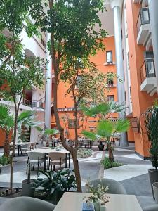 an empty courtyard with tables and trees in a building at Ararat Hotel in Yerevan