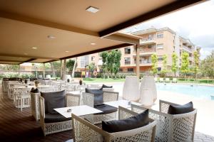 a restaurant with tables and chairs and a pool at Hotel SB Corona Tortosa in Tortosa