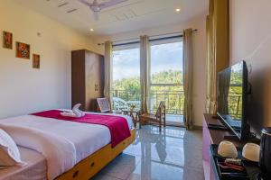 a bedroom with a bed and a large window at Mukteshwar Valley Resort in Mukteshwar +148 photos
