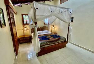 a bedroom with a bed with a canopy at Uva Blue Villas - Zen Villa 1 - 3 Bedroom Villa, Private Garden & Yoga Deck in Puerto Viejo +9 photos