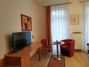 a living room with a television and a table and chairs at Ratskeller in Salzhemmendorf