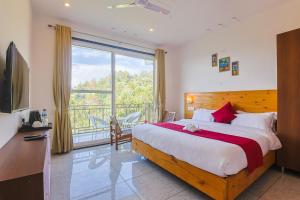 a bedroom with a large bed and a large window at Mukteshwar Valley Resort in Mukteshwar