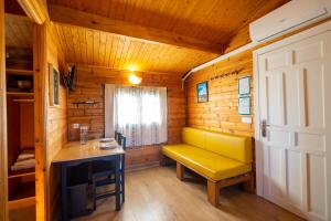 a room with a yellow bench in a wooden cabin at Camping Cantabria in Polientes