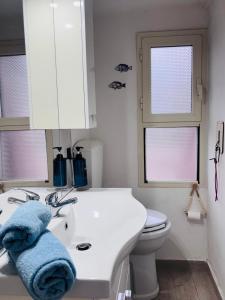 a bathroom with a white sink and a toilet at Cavo Beach 3 in Cavo