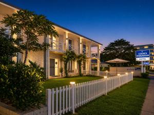 a white picket fence in front of a house at Cooks Endeavour Motor Inn - Near beach & Gold Coast Airport in Tweed Heads