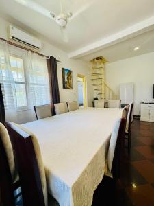 a large white bed in a room with chairs at We Call it Home - Bububu Villa in Mtoni