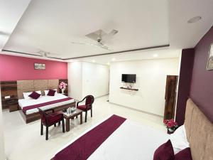 a bedroom with a bed and a table and chairs at Hotel Exotica Haridwar in Rāiwāla