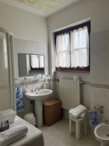 a white bathroom with a sink and a mirror at Agriturismo Il Fornello in Volterra +32 photos