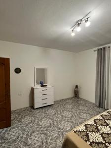 a bedroom with a bed and a dresser with a mirror at Villa serenità in Tirana