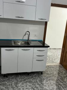 a kitchen with white cabinets and a sink at Villa serenità in Tirana