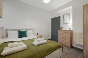 a bedroom with a large bed with towels on it at Spacious 5-Bed Flat in Stockton, Sleeps 9 in Stockton-on-Tees
