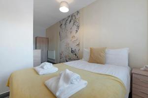 a bedroom with a bed with towels on it at Spacious 5-Bed Flat in Stockton, Sleeps 9 in Stockton-on-Tees