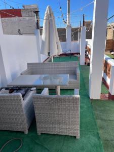 a patio with wicker tables and chairs on a roof at ÁTICO HOME y Garaje, Algemesi Home in Algemesí