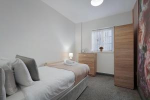 a bedroom with a bed and a dresser and a window at Spacious 5-Bed Flat in Stockton, Sleeps 9 in Stockton-on-Tees