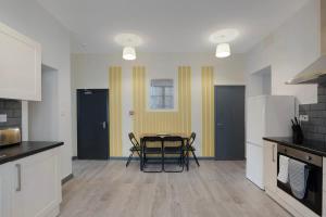a kitchen with a table and chairs in it at Spacious 5-Bed Flat in Stockton, Sleeps 9 in Stockton-on-Tees +42 photos