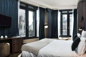 a bedroom with a large bed with windows and a television at CasaÔ in Paris