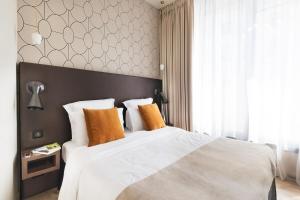 a bedroom with a large white bed with orange pillows at CasaÔ in Paris