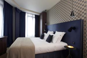 a bedroom with a large bed with a blue wall at CasaÔ in Paris