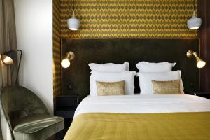 a bedroom with a large bed and a chair at CasaÔ in Paris +3 photos