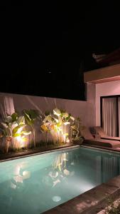 a swimming pool in front of a house at night at Pondok Wahyu in Ubud