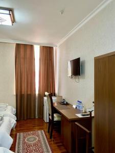 a hotel room with a desk and a bed at Hotel Vardonze in Bukhara