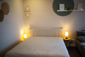a bedroom with a white bed and two lamps at Ferienwohnung Saarglück in Merzig