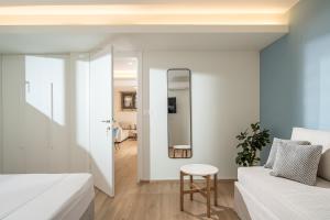 a bedroom with a bed and a stool next to a mirror at Arvacay Luxury Home in Malia