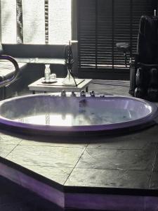 a large purple bath tub with a sink at Bed & Wellness Malina Deluxe zwembad suite in Lelystad
