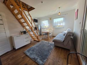 a living room with a staircase and a table at Holiday House Lawendowa Przystań - dom z jacuzzi nad jeziorem in Miszkowice