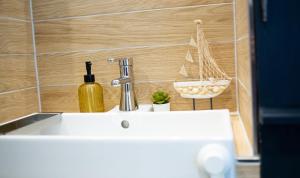 a sink with a bottle of wine and a boat on the wall at Ferienwohnung Saarglück in Merzig +16 photos