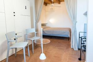 a bedroom with a bed and two chairs and a table at Casa Cortese Sirolo in Sirolo