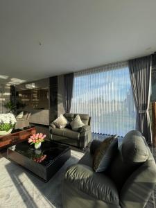 a living room with a leather couch and a large window at The Quadrant Hotel Ocarina Batam in Batam Center