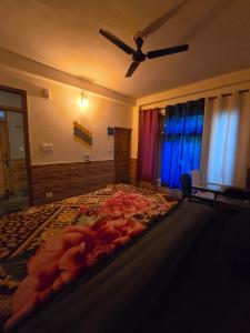 a bedroom with a large bed with a ceiling fan at Flipsyde Retreat in Kasol
