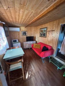 a living room with a red couch and a table at Camping Roma in Ventimiglia