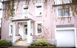 a pink house with a large white garage at Ferienwohnung Saarglück in Merzig
