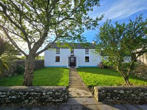 a white house with trees in front of it at Newgale Lodge in Newgale