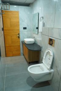a bathroom with a toilet and a sink and a door at Hotel Starwing in Pāonta Sāhib +16 photos