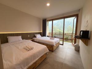 a hotel room with two beds and a balcony at HLB Homestay in Ngadisari +7 photos