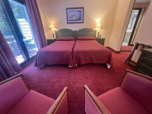 ein Hotelzimmer mit zwei Betten und zwei Stühlen in der Unterkunft Rutllan & Spa in La Massana + 67 Fotos