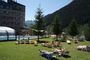 a group of people laying in lawn chairs by a pool at Apartarent 1500 - Apartamento Sanglier in Baqueira-Beret